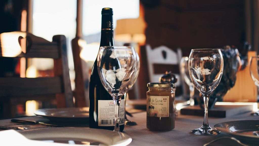 Gedekte tafel in een sfeervol restaurant met wijn, honingpot en glazen – perfect voorbeeld van herbestemming horeca.