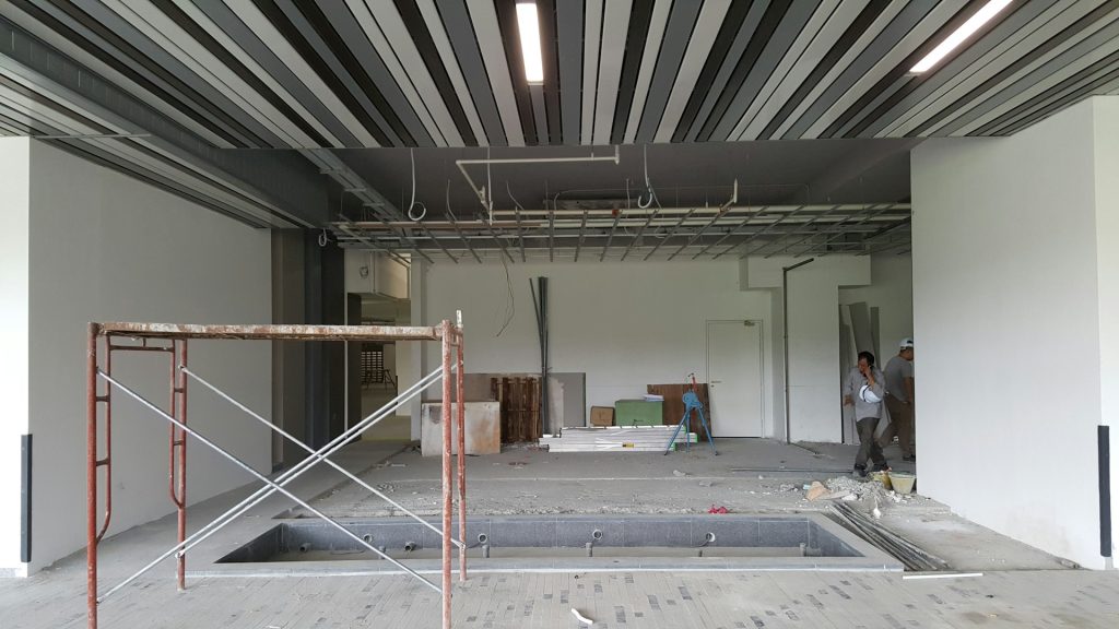 Verbouwing van een oud pand voor herbestemming horeca met steiger, bouwmateriaal en werklieden in actie.