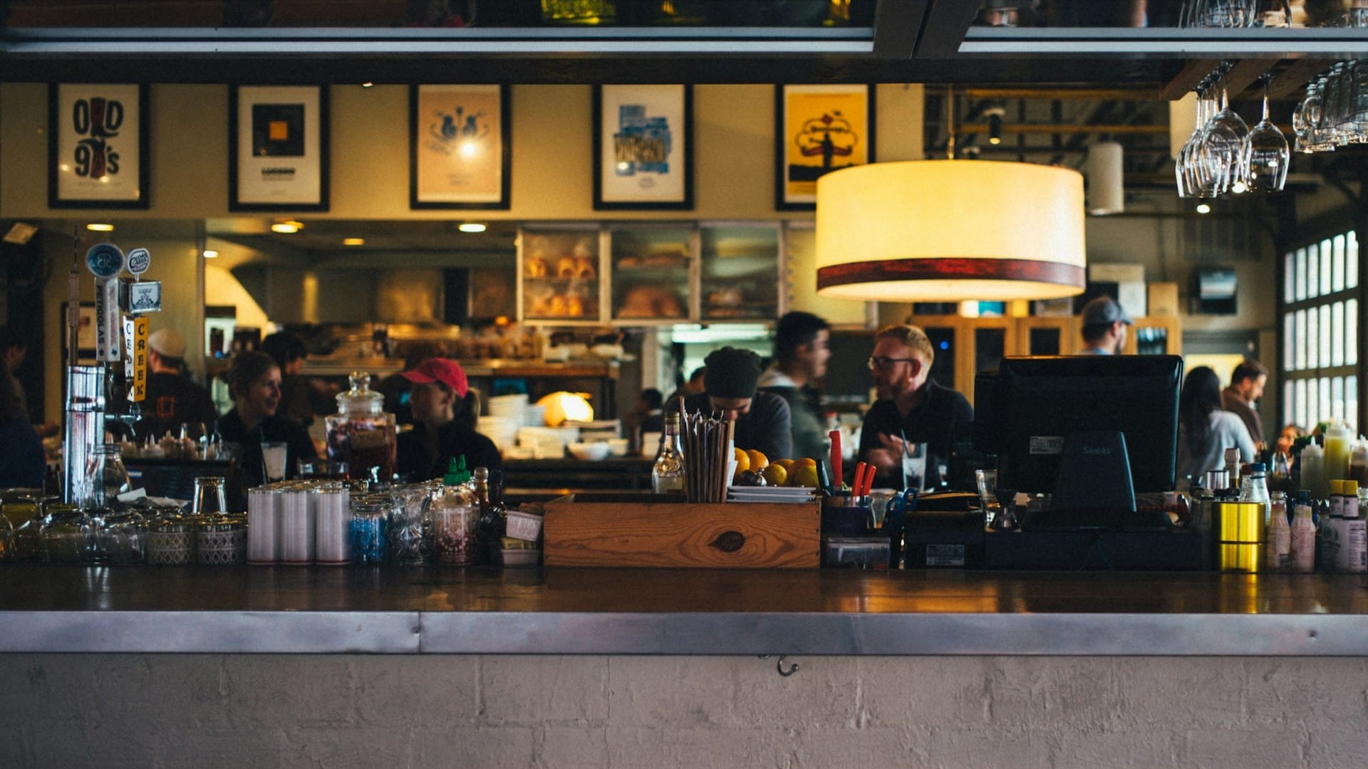 Gezellige drukte in een modern restaurant met open keuken en bar – herbestemming horeca in actie.