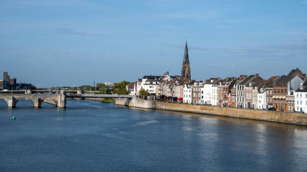 Uitzicht op Maastricht vanaf de Maas met historische gevels, brug en kerktoren tijdens culinaire tour